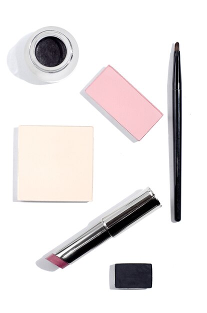 Vue de dessus sur les cosmétiques. rouge à lèvres, blush, ombre à paupières sur fond blanc