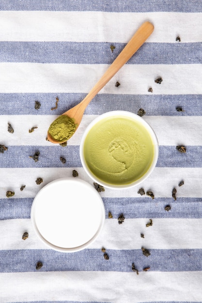Vue de dessus de la crème glacée au thé vert matcha dans une tasse en papier blanc avec de la poudre de matcha