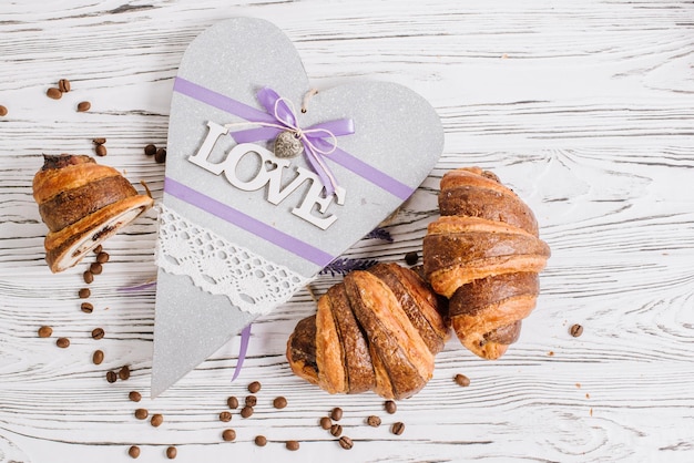 Vue de dessus des croissants frais avec une forme de coeur sur le fond en bois blanc