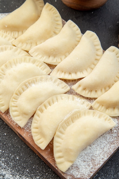 vue de dessus crus petits petits pains chauds avec de la farine de pommes de terre en purée et des œufs sur fond sombre pâte à tarte cuire cuisson biscuit gâteau nourriture