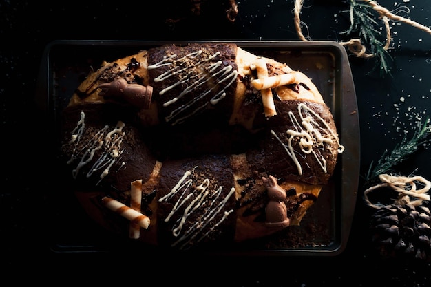 Vue de dessus de la cuisine mexicaine traditionnelle, délicieuse Rosca de reyes au chocolat sur fond noir.