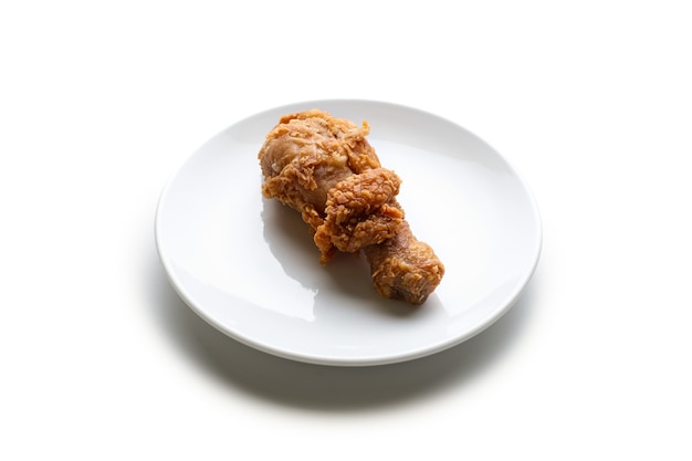 Vue de dessus cuisse de poulet frit dans une assiette blanche isolée sur blanc
