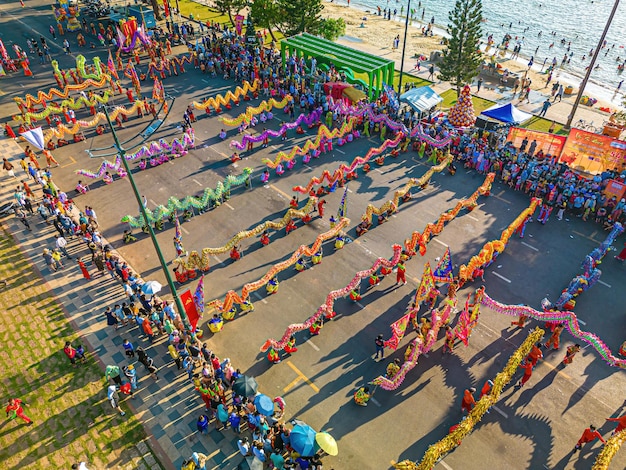 Vue de dessus de la danse du dragon lors de la célébration du nouvel an Un groupe de personnes exécute une danse traditionnelle du lion et une danse du dragon Performance record Guinness de 54 danses de dragons dans la rue Vung Tau