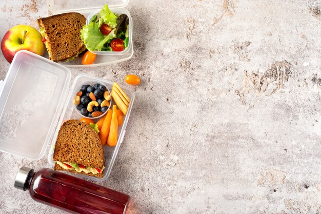 Vue De Dessus Des Déjeuners Scolaires Végétaliens Avec Des Sandwichs Sains, De La Salade Et Des Fruits