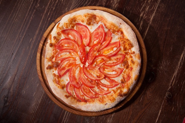 Vue de dessus d'une délicieuse pizza Margherita fraîchement cuite sur une plaque en bois