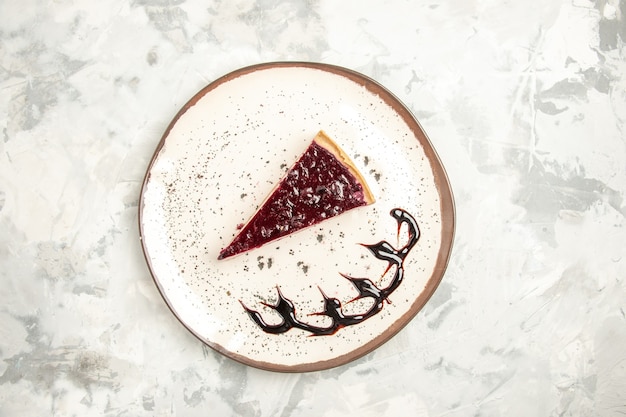 Vue de dessus délicieuse tranche de gâteau au fromage à l'intérieur de la plaque sur fond blanc gâteau aux biscuits biscuit sucré crème glacée tarte au thé dessert