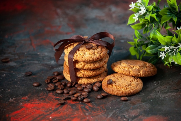 Vue de dessus de délicieux biscuits au sucre et pot de fleur de grains de café sur fond de couleurs sombres