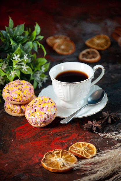Vue de dessus de délicieux biscuits au sucre et une tasse de pot de fleur de café tranches de citron séchées sur fond de couleurs sombres