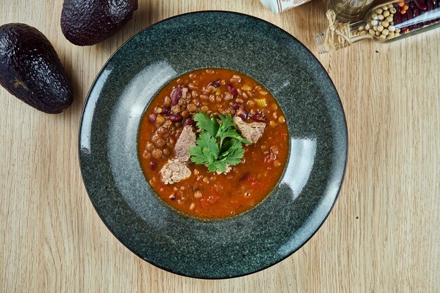 Vue de dessus sur un délicieux Chili con carne ou chili avec de la viande, un ragoût épicé contenant des piments, de la viande, des haricots, de la tomate. Cuisine traditionnelle du sud du Texas.