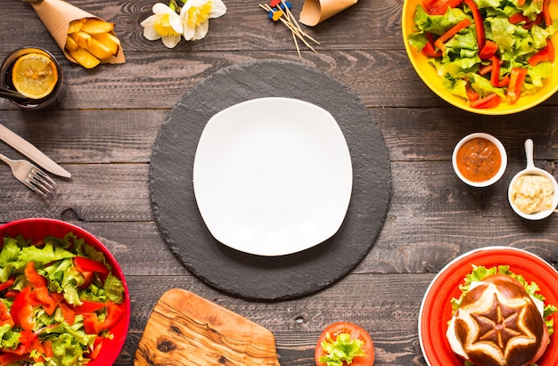 Vue de dessus d'un délicieux hamburger, avec des légumes, sur une surface en bois.