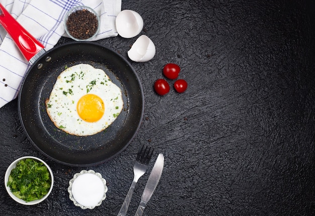 Vue de dessus de délicieux œufs au plat dans une casserole sur la surface noire