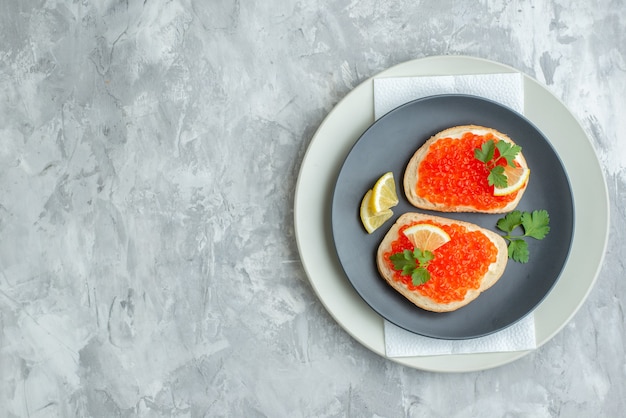 vue de dessus de délicieux sandwichs au caviar à l'intérieur de la plaque sur une surface blanche