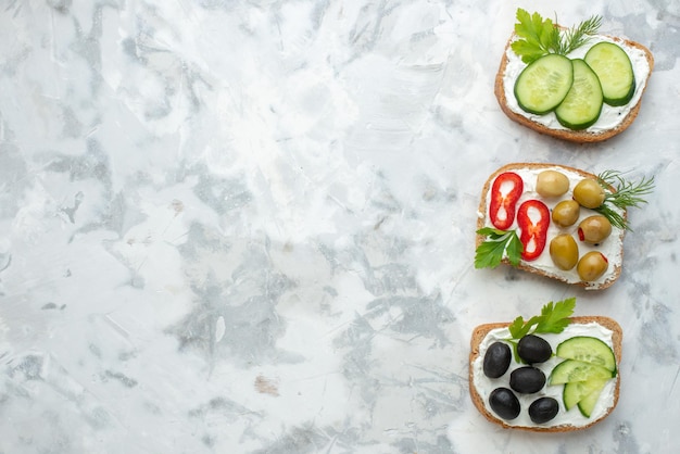 Vue de dessus de délicieux sandwichs aux concombres et olives fond blanc déjeuner nourriture sandwich repas horizontal burger pain toast espace libre