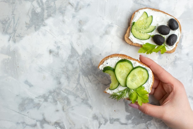 Vue de dessus de délicieux sandwichs aux concombres et olives sur fond blanc toast déjeuner nourriture horizontale pain burger santé repas