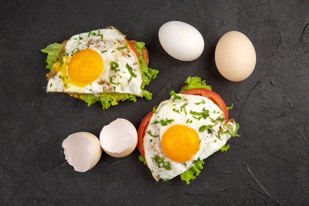 vue de dessus de délicieux sandwichs aux œufs avec des œufs frais sur fond sombre faire bouillir les repas petit déjeuner nourriture omelette pain aux œufs déjeuner