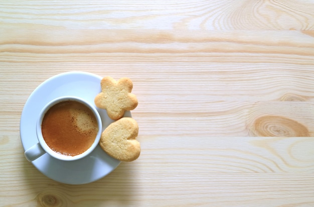 Vue de dessus de deux biscuits au beurre avec une tasse de café sur la table en bois