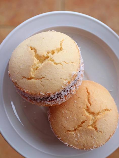 Vue de dessus de deux bonbons latino-américains traditionnels Alfajores servis sur une assiette blanche