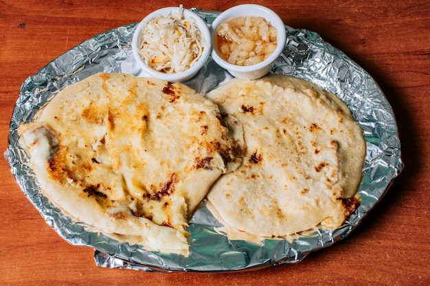 Vue de dessus de deux pupusas nicaraguayennes servies avec salade sur la table Délicieuses pupusas salvadoriennes avec fromage fondu servies sur la table Pupusas traditionnelles servies avec salade sur la table