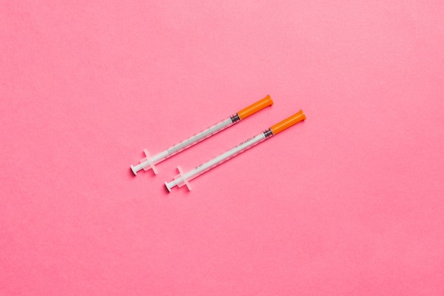 Vue de dessus de deux seringues à insuline à surface colorée avec espace de copie