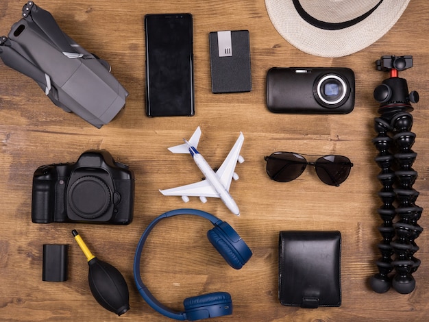 Vue de dessus de différents accessoires de cinéaste sur une table en bois. Appareil photo moderne. Drone moderne. Casque