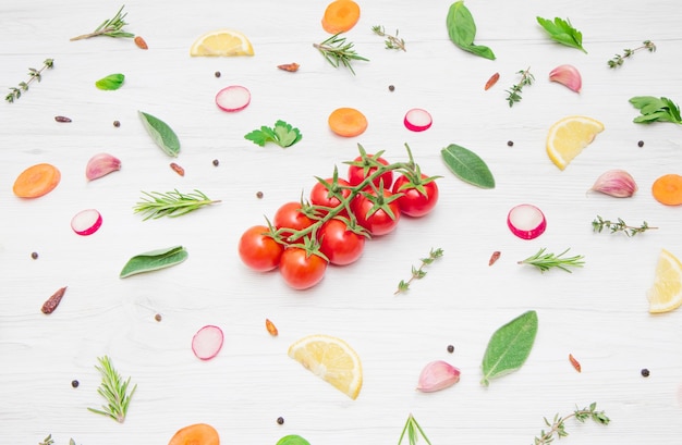 Vue de dessus de divers types de feuilles d'herbes aromatiques et légumes coupés sur une surface en bois