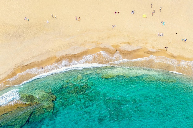 Vue de dessus drone aérien photo de belle plage avec de belles vagues de mer d'eau turquoise et des gens fond de voyage de vacances Grèce