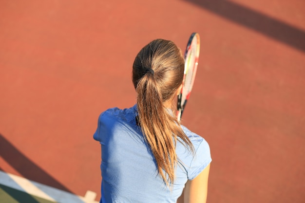 Vue de dessus du beau joueur de tennis prêt à servir la balle sur le court de tennis.