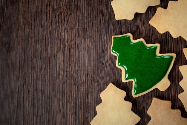 Vue de dessus du biscuit au sucre de sapin de Noël décoré sur fond de table en bois