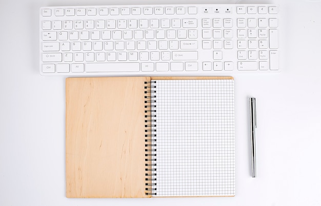 Vue de dessus du bureau blanc avec clavier et ordinateur portable. Espace de copie, entreprise