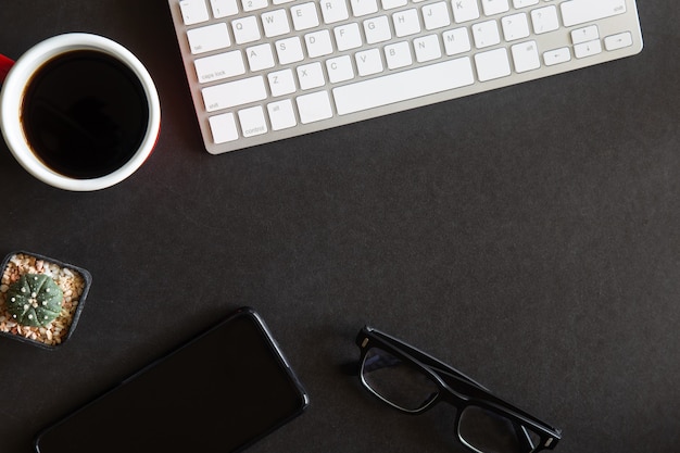 Vue de dessus du bureau noir avec fournitures et appareils de bureau