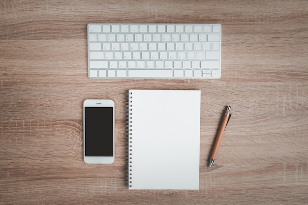 Vue de dessus du bureau avec ordinateur portable et clavier.