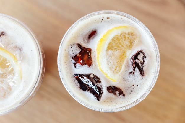 Vue de dessus du café infusé froid nitro au citron sur une table en bois