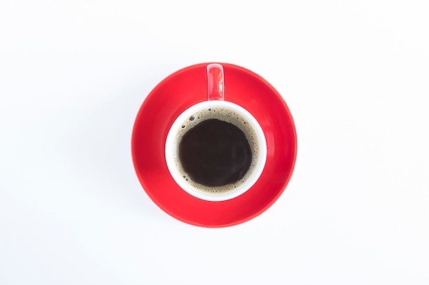 Vue de dessus du café noir dans la tasse rouge sur fond blanc. Fermer.