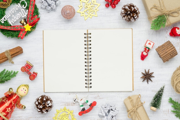 Vue de dessus du cahier vierge sur fond blanc avec des décorations d'ornements de Noël