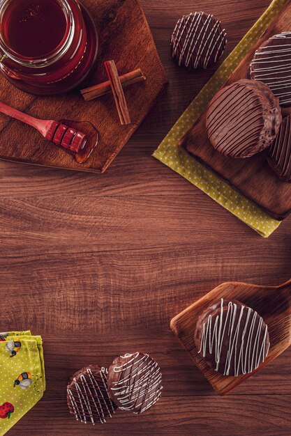 Vue de dessus du chocolat biscuit au miel brésilien recouvert sur la table en bois avec abeille et cannelle - PÃ £ o de mel