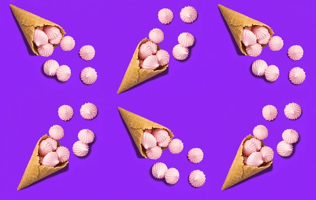 Vue de dessus du cornet de crème glacée avec meringue rose sur fond violet