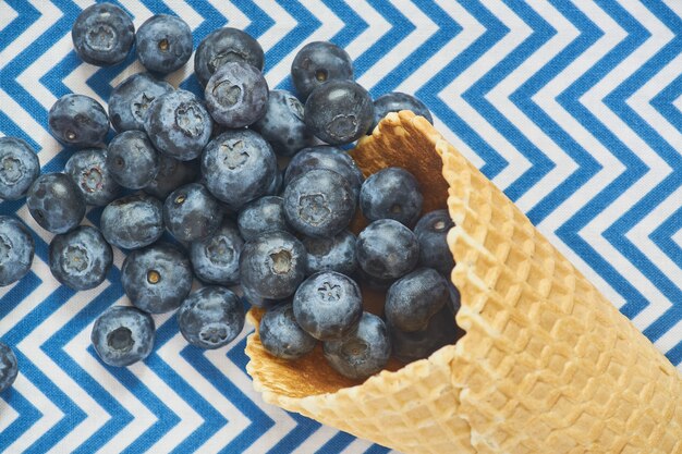 Vue de dessus du cornet gaufré aux bleuets sur textile bleu