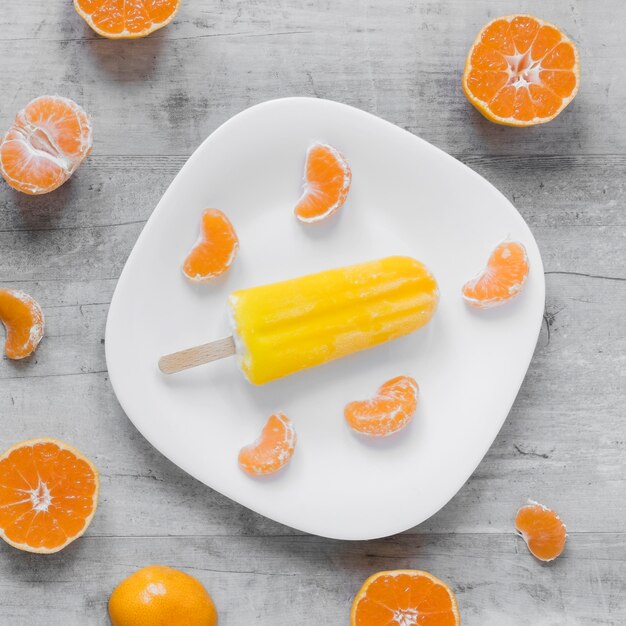 Vue de dessus du délicieux popsicle sur plaque avec orange