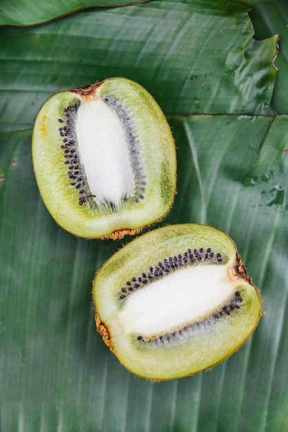 Vue de dessus du demi-kiwi thaïlandais coupé sur des feuilles de bananier. Exemple goût fruité du café.