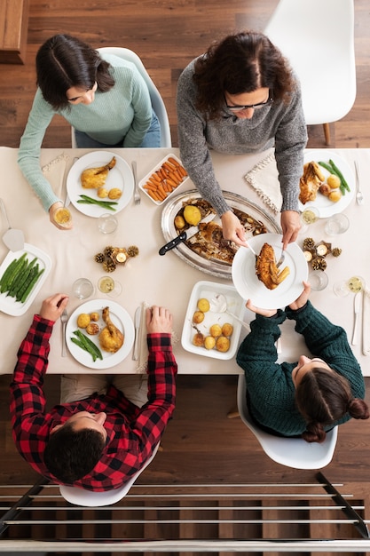 Vue de dessus du dîner de Noël en famille La mère sert des rôtis à sa fille Vacances verticales