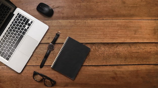 Vue de dessus du fond en bois avec des lunettes pour ordinateur portable et un carnet de croquis vintage