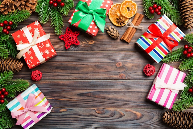 Vue de dessus du fond de Noël fait de sapin, cadeaux et autres décations sur fond en bois. Concept de vacances de nouvel an avec espace de copie