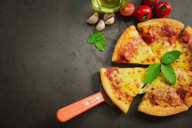 Vue de dessus du fromage à pizza chaud, savoureux fromage à pizza sur fond noir.