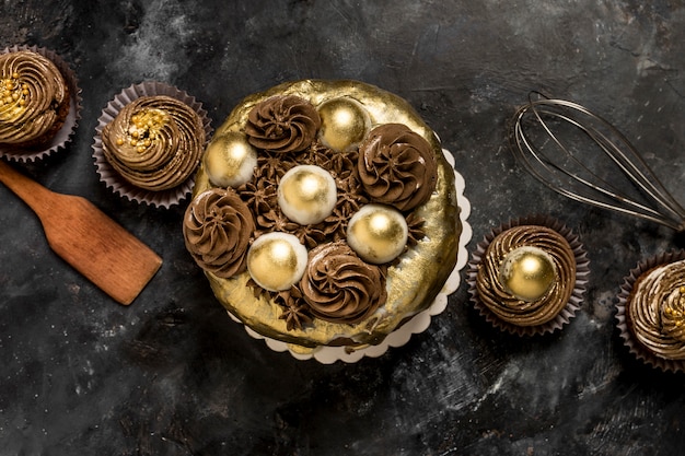 Photo vue de dessus du gâteau avec des cupcakes et du fouet