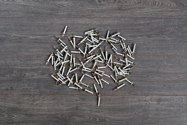 Vue de dessus du groupe de vis ou de chevilles en acier métallique avec des capuchons en plastique isolés sur la table