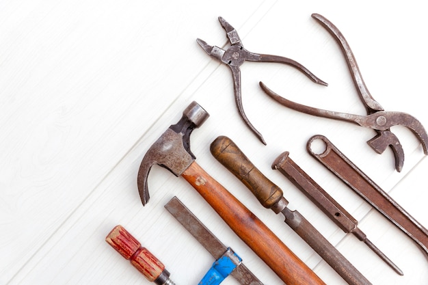 Vue de dessus du jeu d'outils vieux et rouillé sur planche de bois de couleur claire. Concept de bricolage.