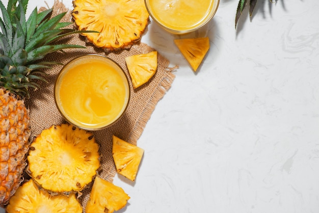 Vue de dessus du jus d'ananas frais dans le verre avec des fruits d'ananas