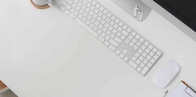Vue de dessus du lieu de travail moderne avec clavier fournitures et fournitures de bureau sur fond de tableau blanc