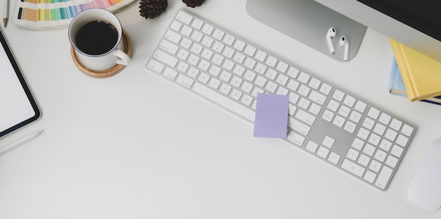 Vue de dessus du lieu de travail moderne avec clavier fournitures et fournitures de bureau sur fond de tableau blanc