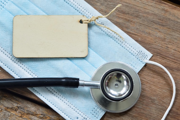 Vue de dessus du masque facial stéthoscope et de l'étiquette en bois écrite avec SAVE LIFE